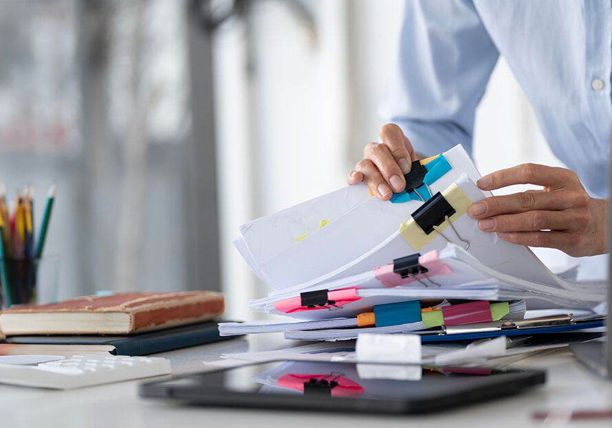 Businesswoman hands working in Stacks of paper files for searching and checking unfinished document achieves on folders papers at busy work desk office